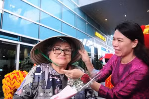 Nguyen Thi Duyen, representante de Anex Tour Vietnam, obsequia un sombrero cónico tradicional a una visitante rusa. (Foto: tuoitre.vn)