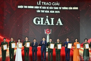 El presidente Luong Cuong y el miembro permanente del Secretariado del Comité Central del PCV, Tran Cam Tu, entregan los premios A a los autores y grupos de autores galardonados. (Foto: VNA)