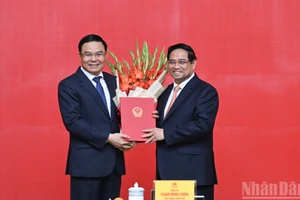El primer ministro de Vietnam, Pham Minh Chinh, entrega la decisión de nombrar a Le Manh Hung, como ministro interino de Industria y Comercio.