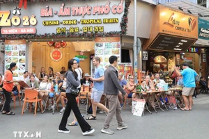 Turistas extranjeros disfrutan de la gastronomía en la calle Ta Hien, Hanói. (Foto: VNA)