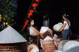 En el mercado, los aldeanos llevan montones de sombreros cónicos a la plaza del pueblo para venderlos. (Foto: VNA)