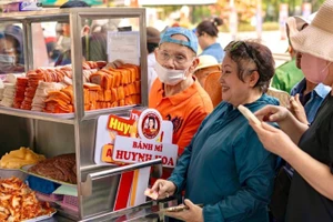 La gente compra banh mi en la tienda de Huynh Hoa. 