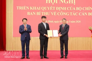 Le Minh Hung, miembro del Buró Político, secretario del Comité Central del Partido y jefe de su Comisión de Organización, entrega la decisión a Tran Huy Tuan. (Foto: VNA)