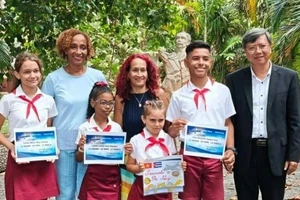 El embajador vietnamita en Cuba, Le Quang Long, y estudiantes galardonados. (Foto: VNA)