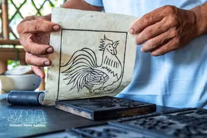 A diferencia de otras corrientes de pintura estampada con múltiples capas de color, la pintura del pueblo de Sinh solo emplea la matriz de madera para definir los contornos, y posteriormente se realiza el coloreado a mano, lo que otorga a cada obra un carácter único. (Foto: VNA)