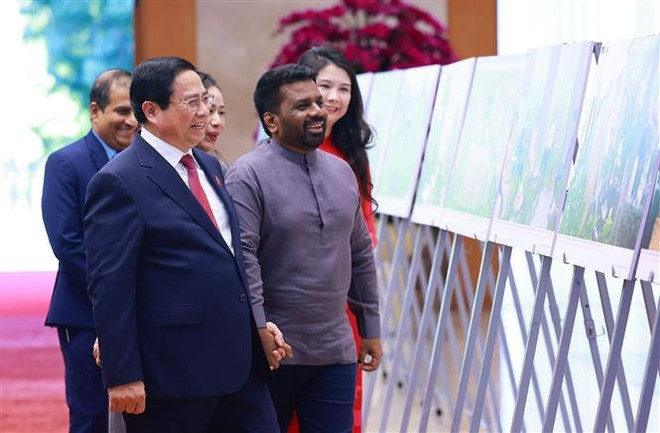 El primer ministro Pham Minh Chinh y el presidente de Sri Lanka, Anura Kumara Dissanayaka, visitan una exposición fotográfica sobre la cooperación entre los dos países producida por la Agencia vietnamita de Noticias (Foto: VNA)