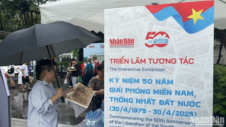 Un lector extranjero muestra interés por la publicación informativa especial de Nhan Dan.