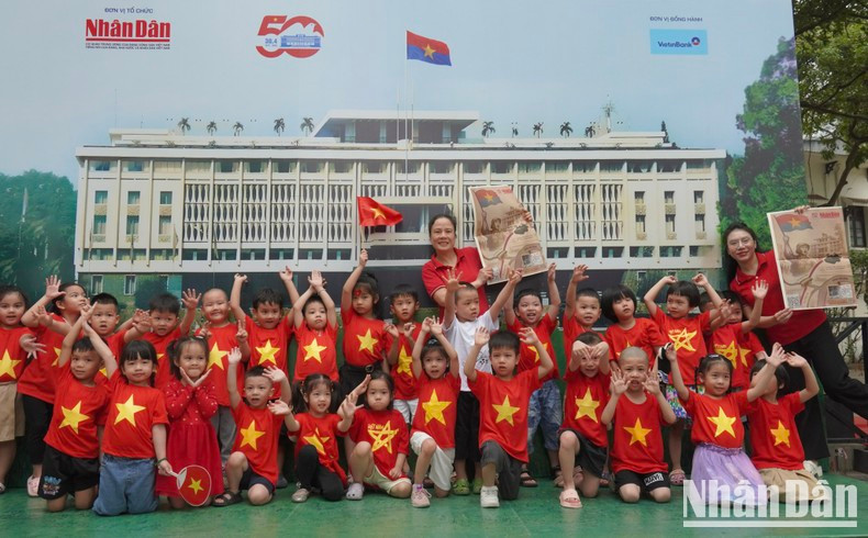 Los niños del jardín de infancia Agosto, con camisetas de la bandera roja y estrellas amarillas, se toman fotos en su visita a la exposición. Los niños del jardín de infancia Agosto, con camisetas de la bandera roja y estrellas amarillas, se toman fotos en su visita a la exposición.