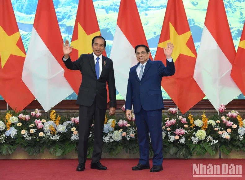 El primer ministro Pham Minh Chinh y el presidente de Indonesia, Joko Widodo, saludan a los periodistas.