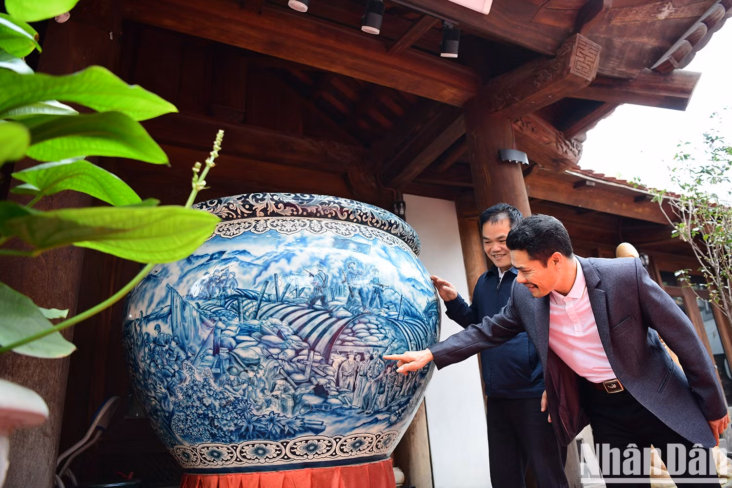 El artesano Dao Viet Binh (izquierda) junto a la obra " Epopeya eterna de heroísmo de Dien Bien", de 1,65 metros de diámetro y 1,1 de alto, que recrea el espíritu heroico de la nación vietnamita a través del arte cerámico.