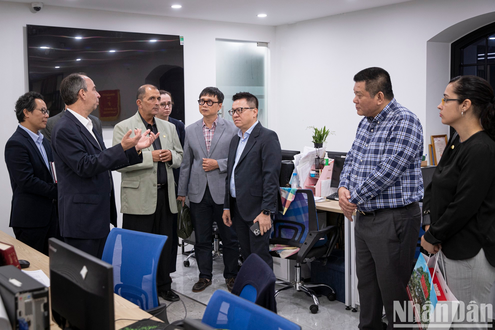 Le Quoc Minh, quien también es subjefe de la Comisión de Comunicación y Educación del Comité Central del Partido Comunista de Vietnam y presidente de la Asociación de Periodistas del país, y los delegados visitan la sala de noticias convergente de la Redacción de Nhan Dan Digital.