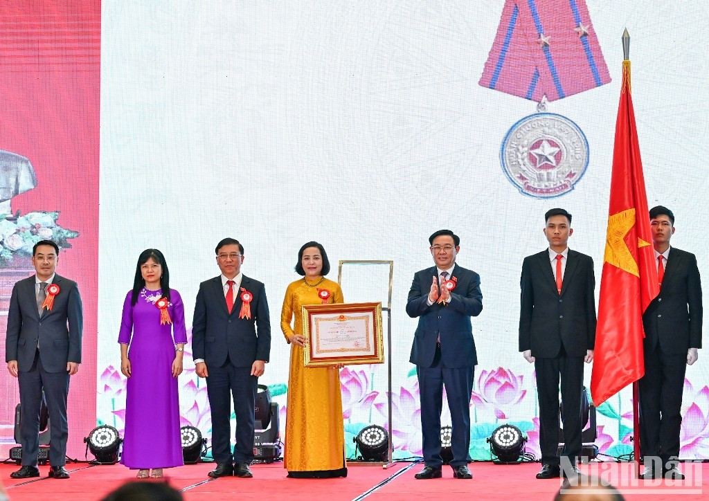 El presidente de la AN, Vuong Dinh Hue, entrega la distinción al comité. El presidente de la AN, Vuong Dinh Hue, entrega la distinción al comité.