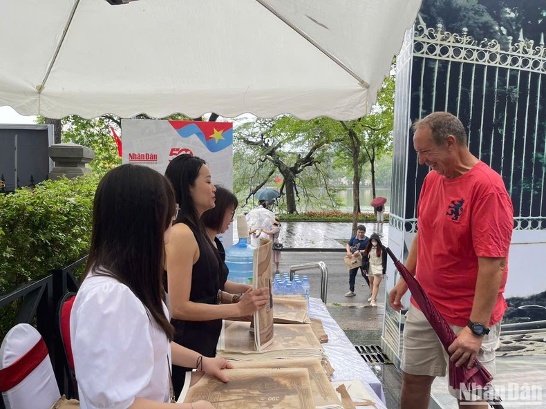 Un lector extranjero muestra interés por la publicación informativa especial de Nhan Dan.