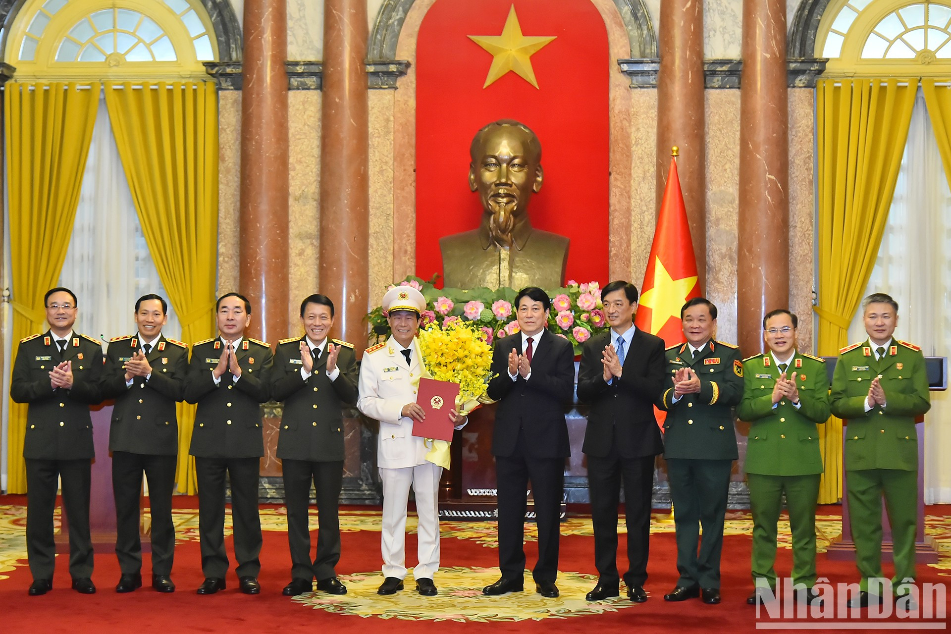 El presidente Luong Cuong y los delegados entregan flores para felicitar al teniente general Le Quoc Hung.