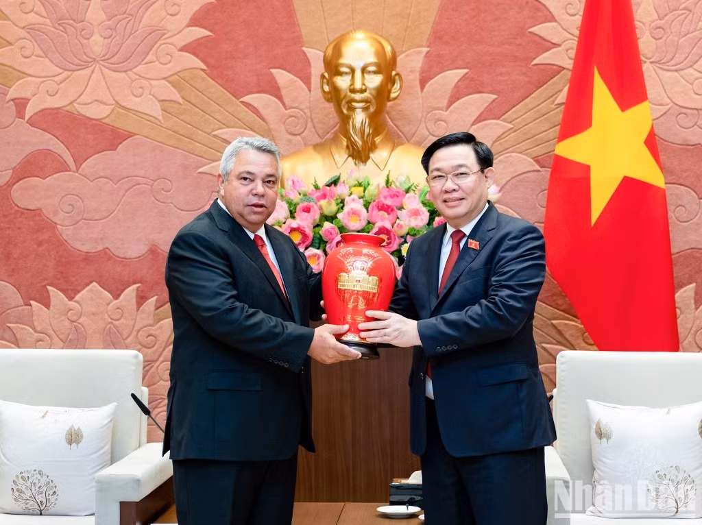 Dinh Hue entrega un regalo al visitante cubano.