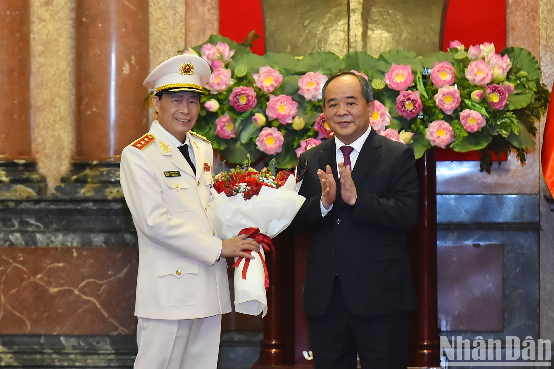 El jefe de la Oficina del presidente, Le Khanh Hai, entrega flores para felicitar al teniente general Le Quoc Hung.