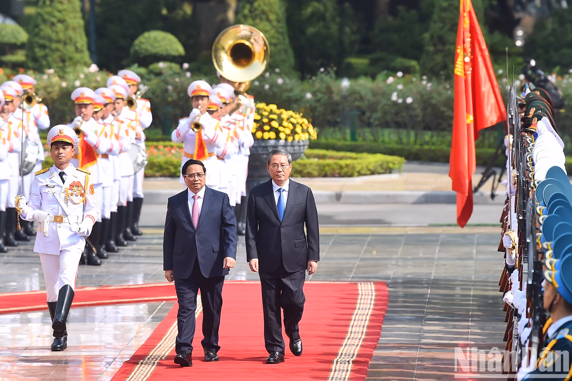 El primer ministro Pham Minh Chinh y su par chino Li Qiang pasan revista a la Guardia de Honor del Ejército Popular de Vietnam en la ceremonia de bienvenida.