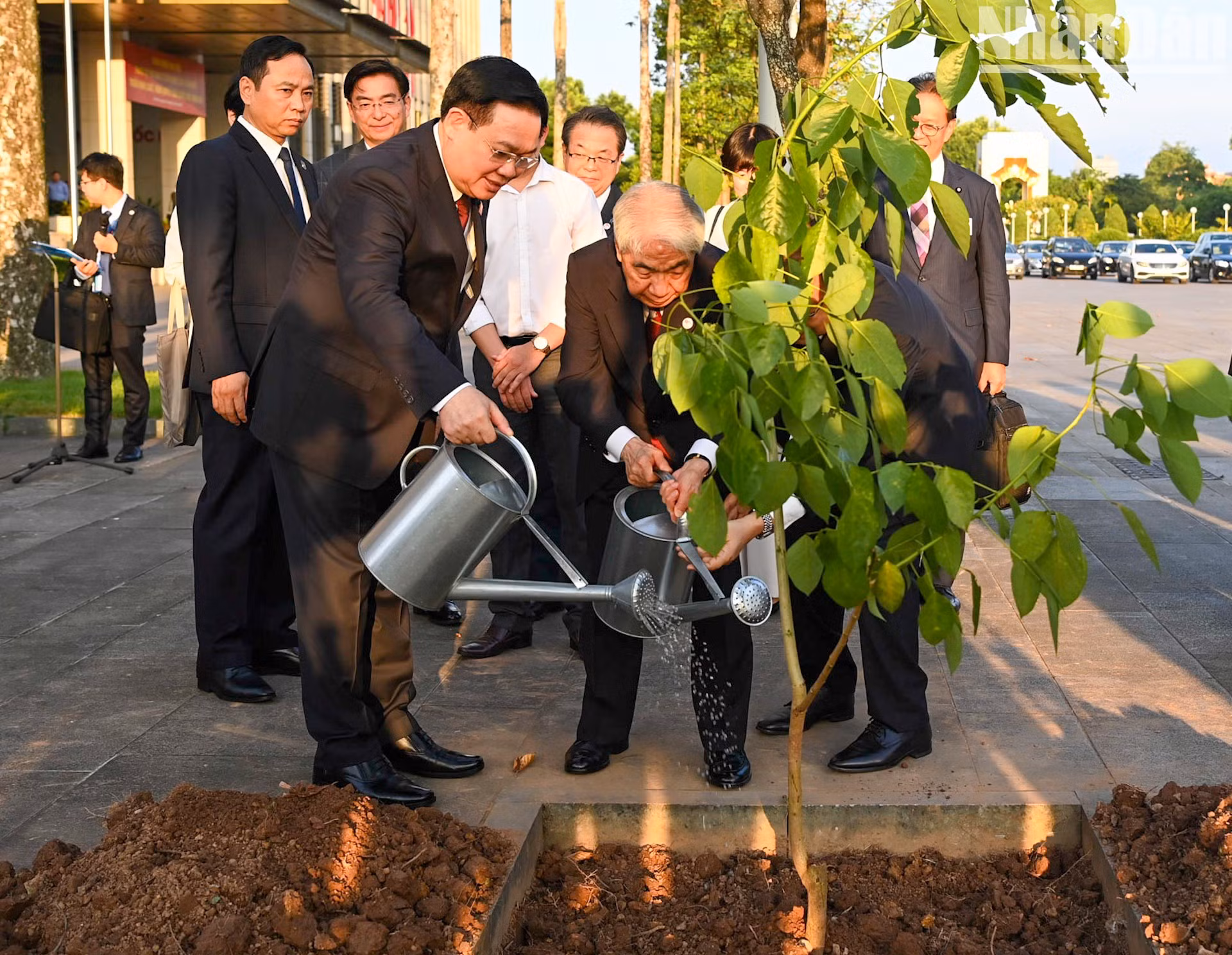 El presidente de la Asamblea Nacional de Vietnam, Vuong Dinh Hue, y el titular de la Cámara de Consejeros de Japón, Otsuji Hidehisa, plantan el árbol de Osaka rojo.