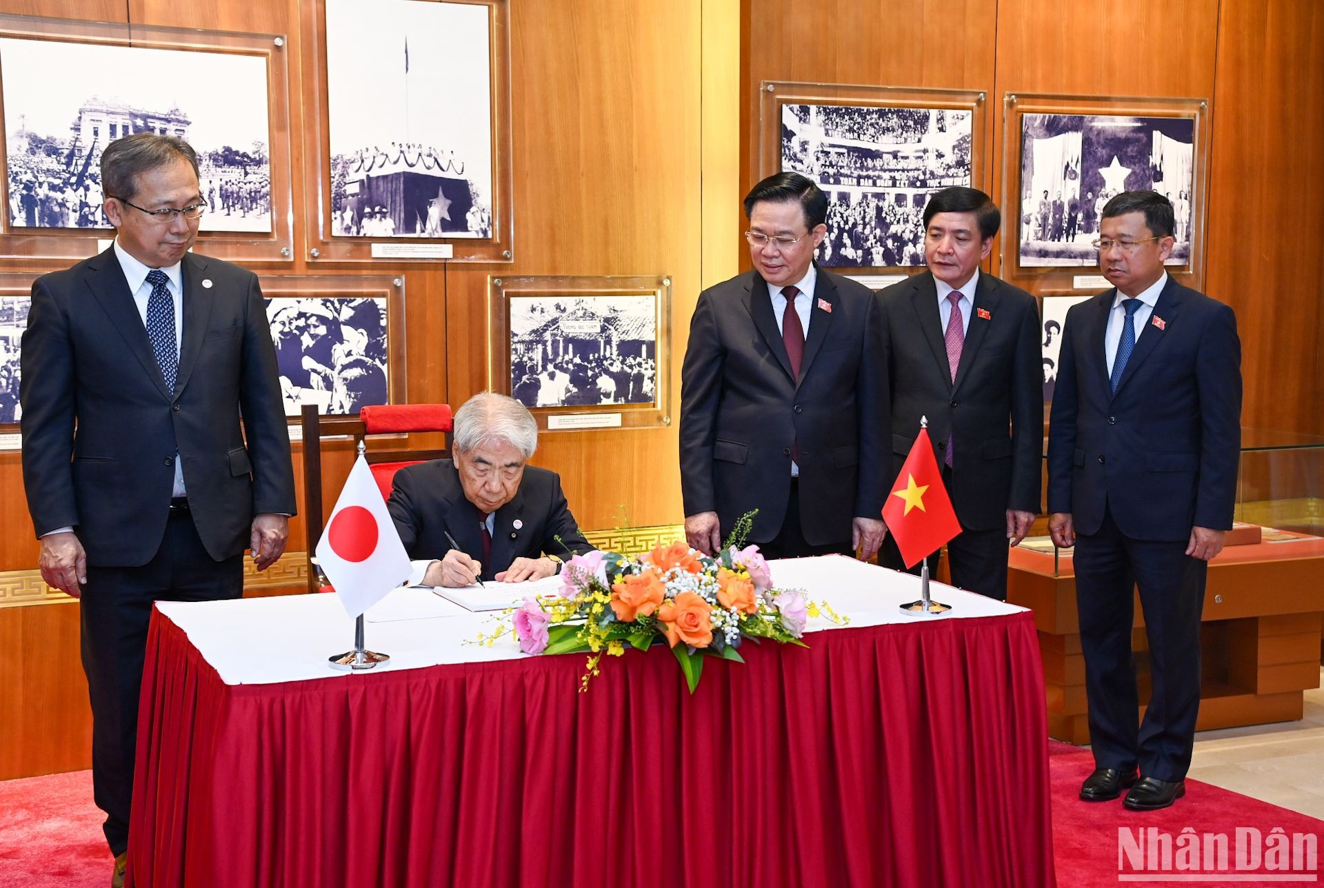 El dirigente legislativo japonés firma el libro de oro de recuerdo.