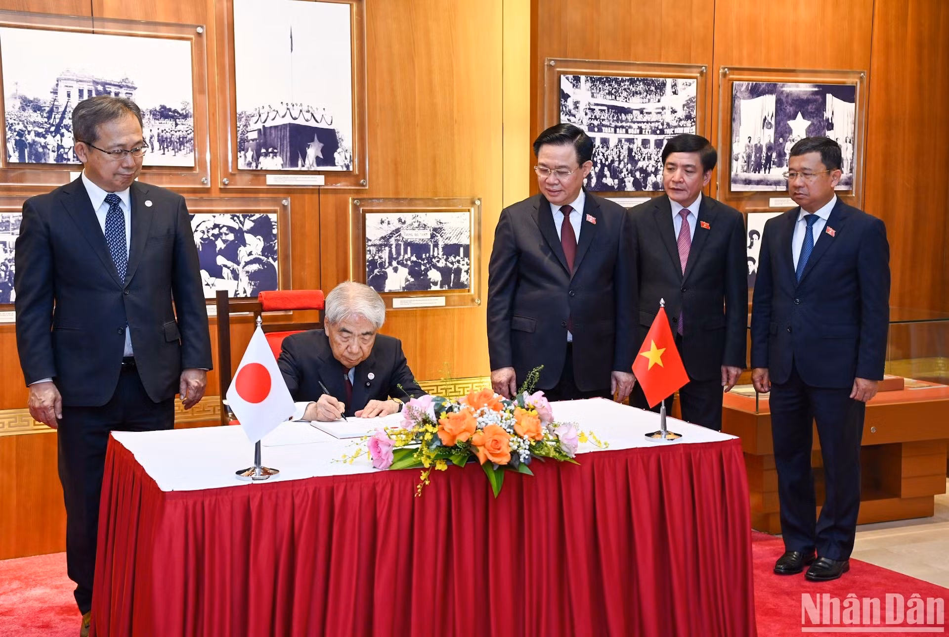 El dirigente legislativo japonés firma el libro de oro de recuerdo.