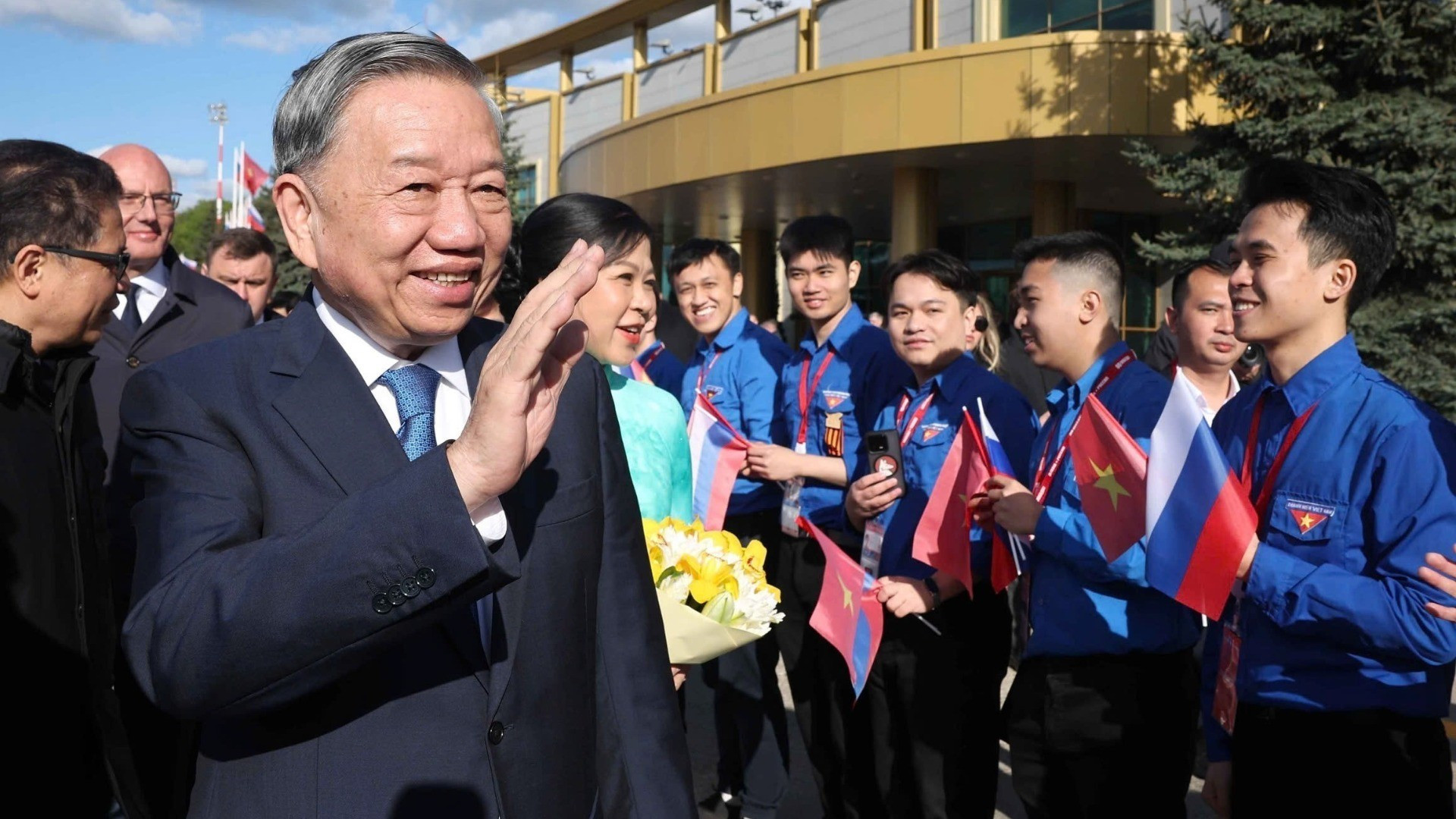 Representantes de la comunidad vietnamita en Rusia dan la bienvenida al líder partidista y a su esposa en el aeropuerto Vnúkovo 2, en Moscú.