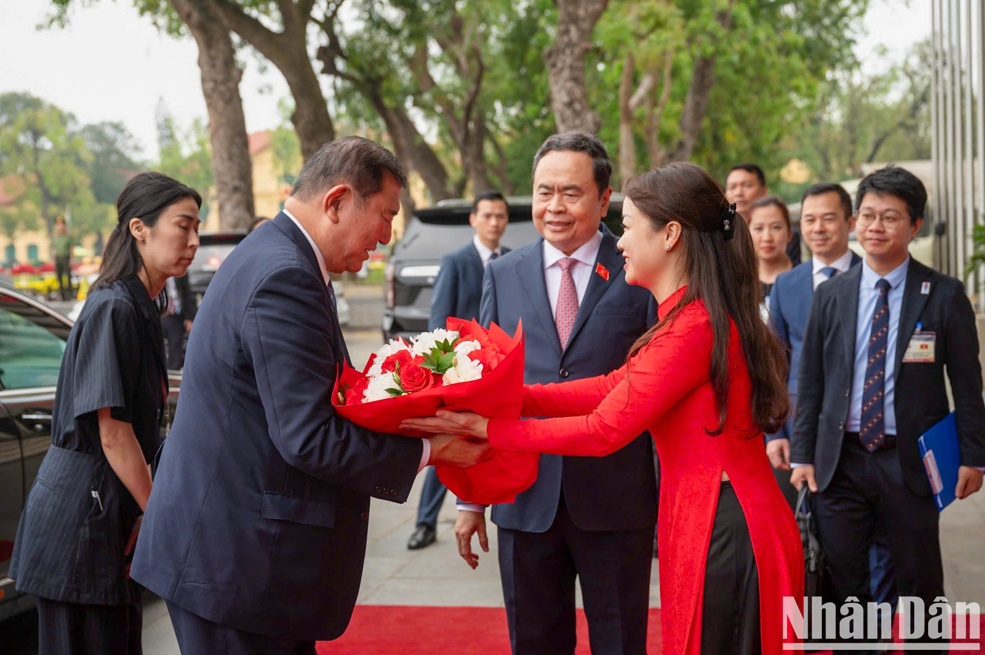 El personal de la Oficina de la Asamblea Nacional de Vietnam entrega flores para dar la bienvenida al premier japonés.
