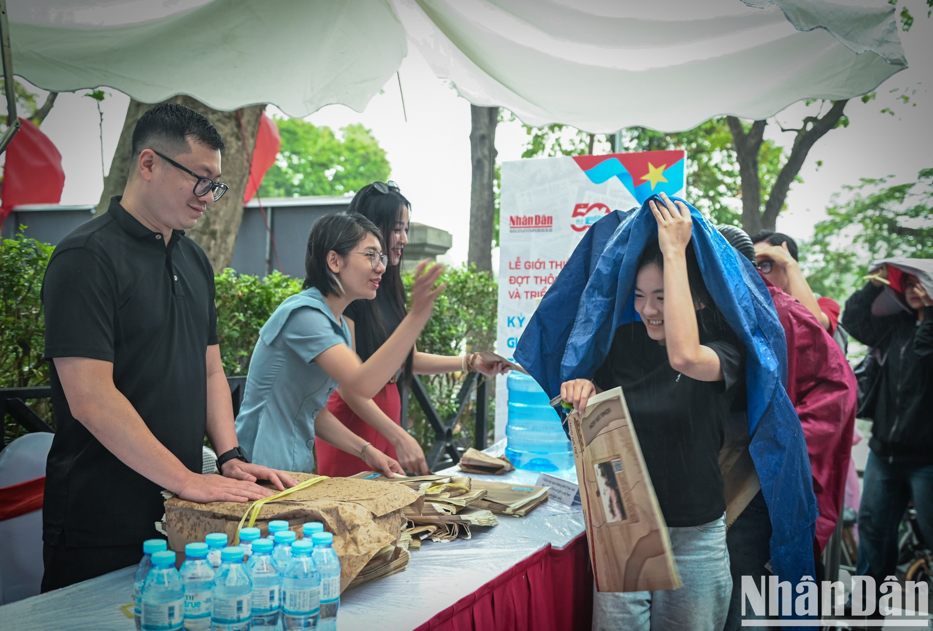 A pesar de la lluvia repentina, muchas personas llegan a recibir el suplemento especial y a visitar la exposición. A pesar de la lluvia repentina, muchas personas llegan a recibir el suplemento especial y a visitar la exposición.
