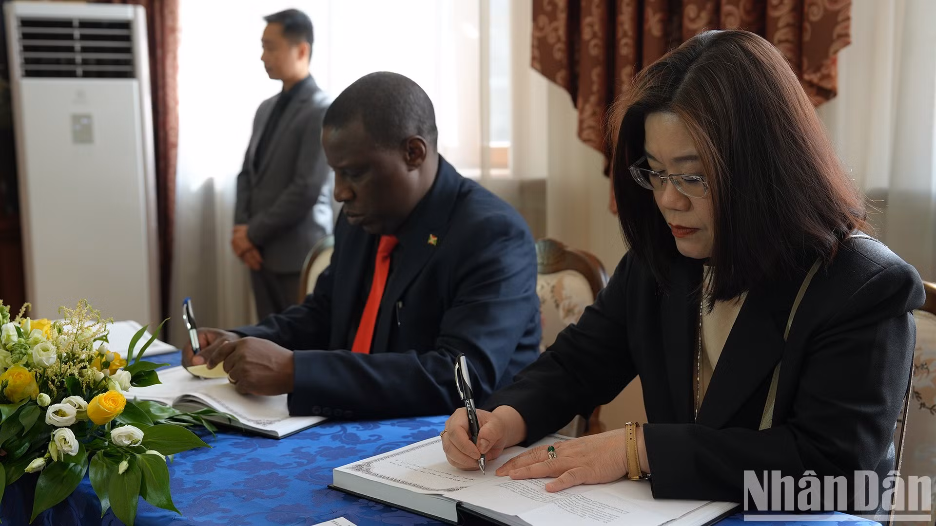 El representante de la Embajada de Tailandia en Rusia escribe en el libro de condolencias.