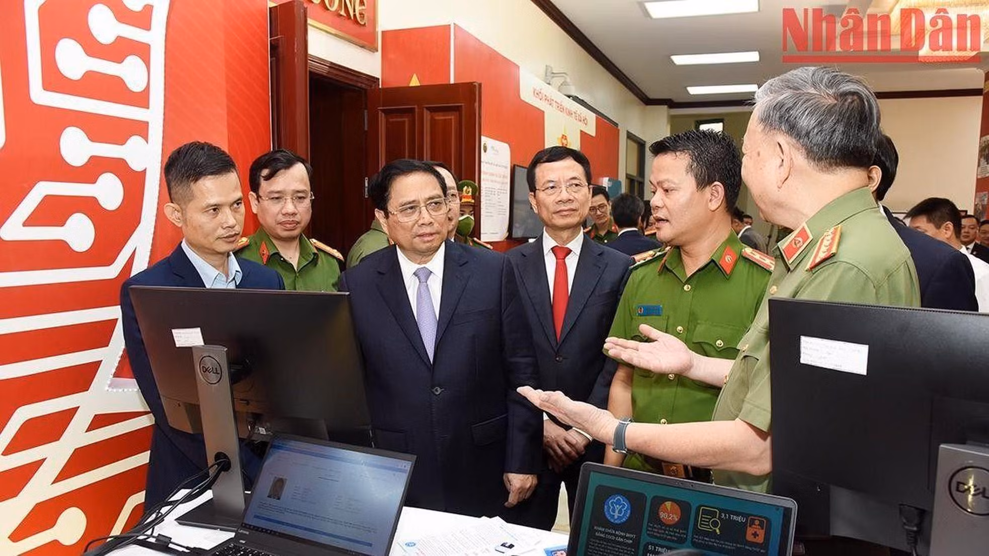 El jefe del Gobierno Pham Minh Chinh y otros delegados observan productos tecnológicos de transformación digital.