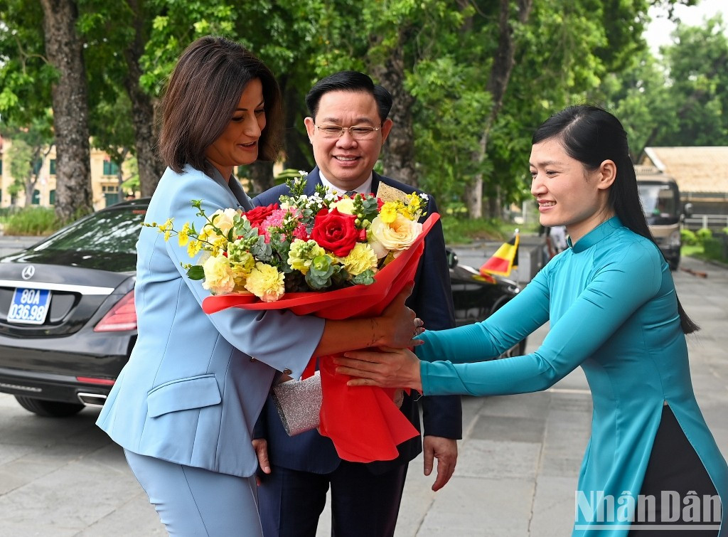 Entrega flores para dar la bienvenida a la visitante belga.