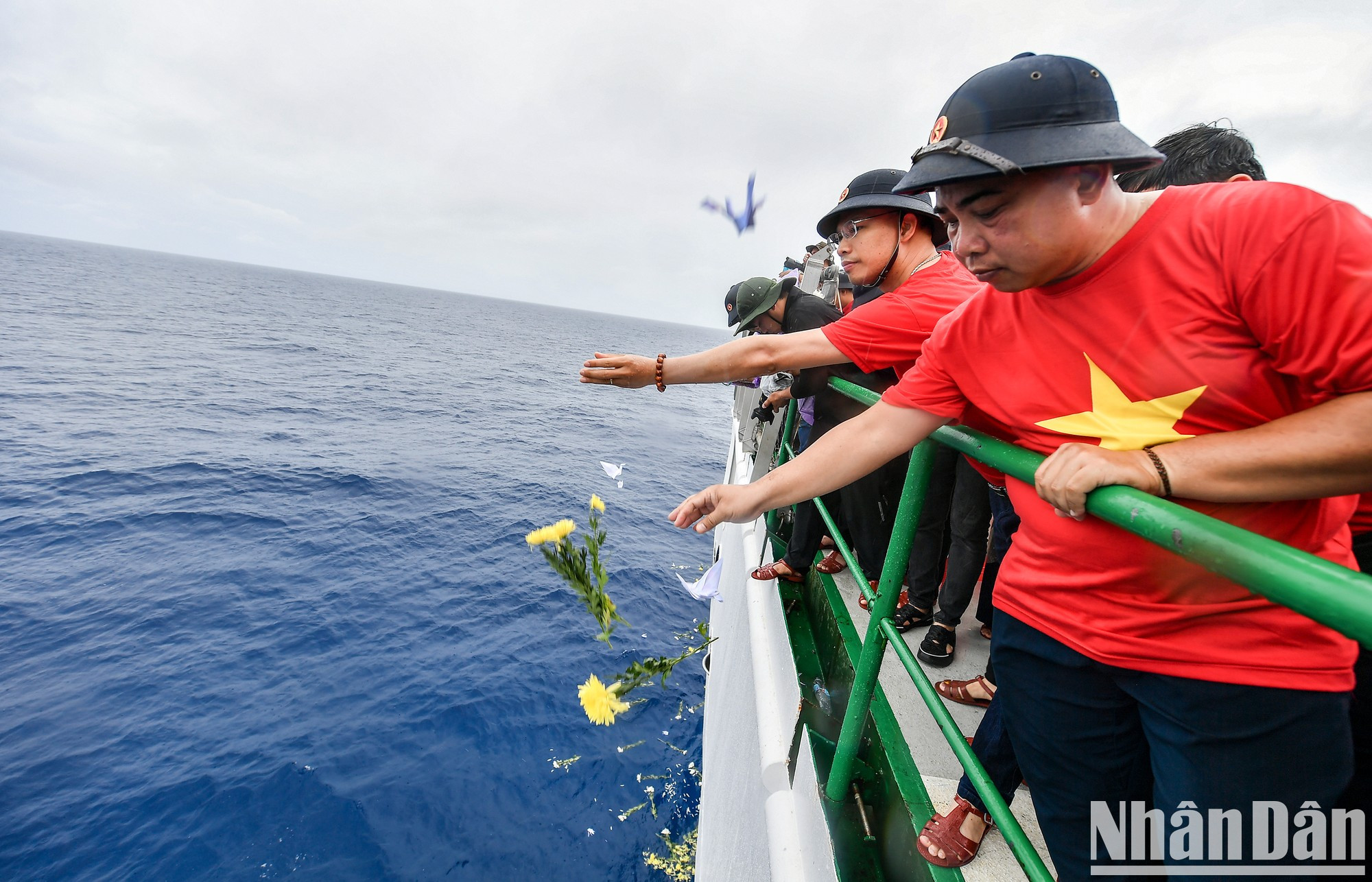 El periodista Pham Huu Quang, subdirector de la revista Ngay Nay (Hoy), no puede contener las lágrimas mientras deja caer flores y grullas de papel para honrar a los mártires. El periodista Pham Huu Quang, subdirector de la revista Ngay Nay (Hoy), no puede contener las lágrimas mientras deja caer flores y grullas de papel para honrar a los mártires.