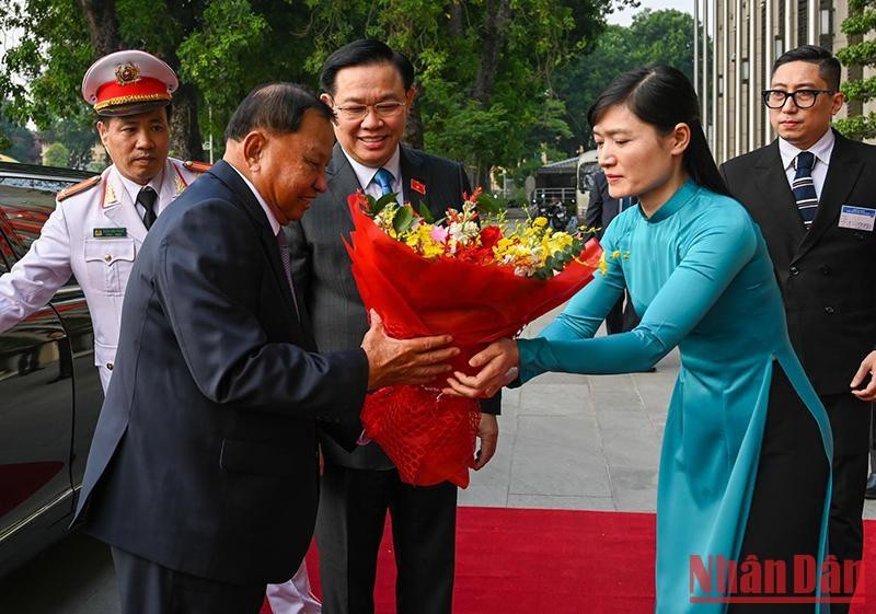 Trabajadora de la Oficina de la Asamblea Nacional de Vietnam entrega flores para dar la bienvenida al dirigente camboyano. Trabajadora de la Oficina de la Asamblea Nacional de Vietnam entrega flores para dar la bienvenida al dirigente camboyano.