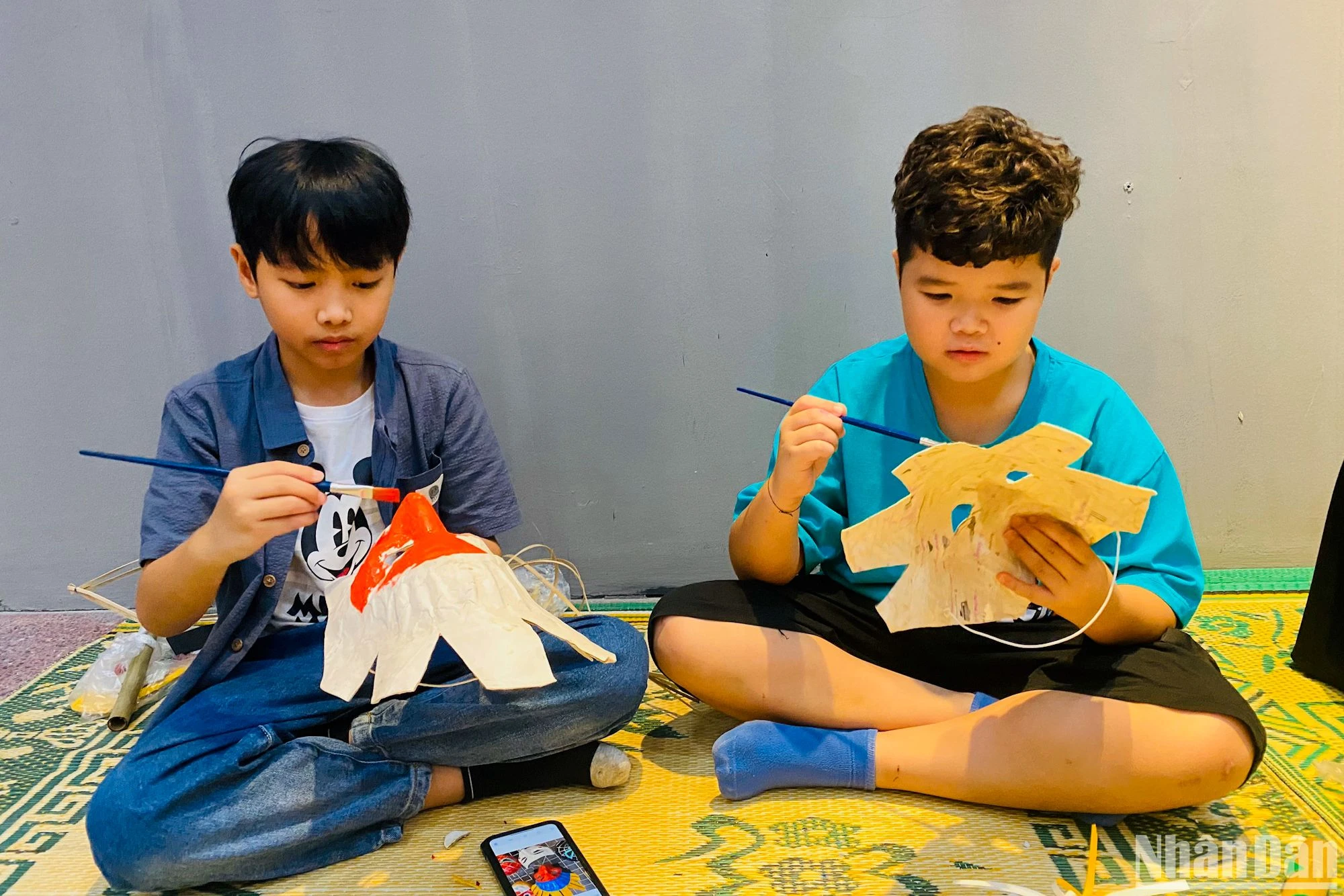 Niños colorean máscaras tradicionales de papel maché. Niños colorean máscaras tradicionales de papel maché.