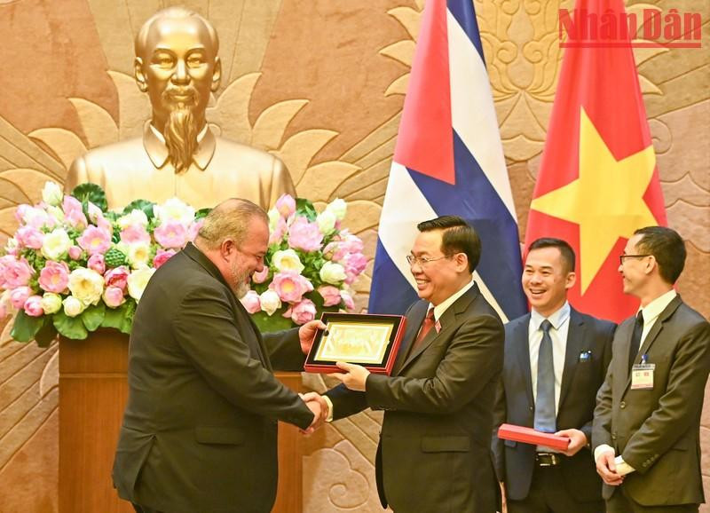 El dirigente anfitrión entrega un regalo de recuerdo al visitante cubano.