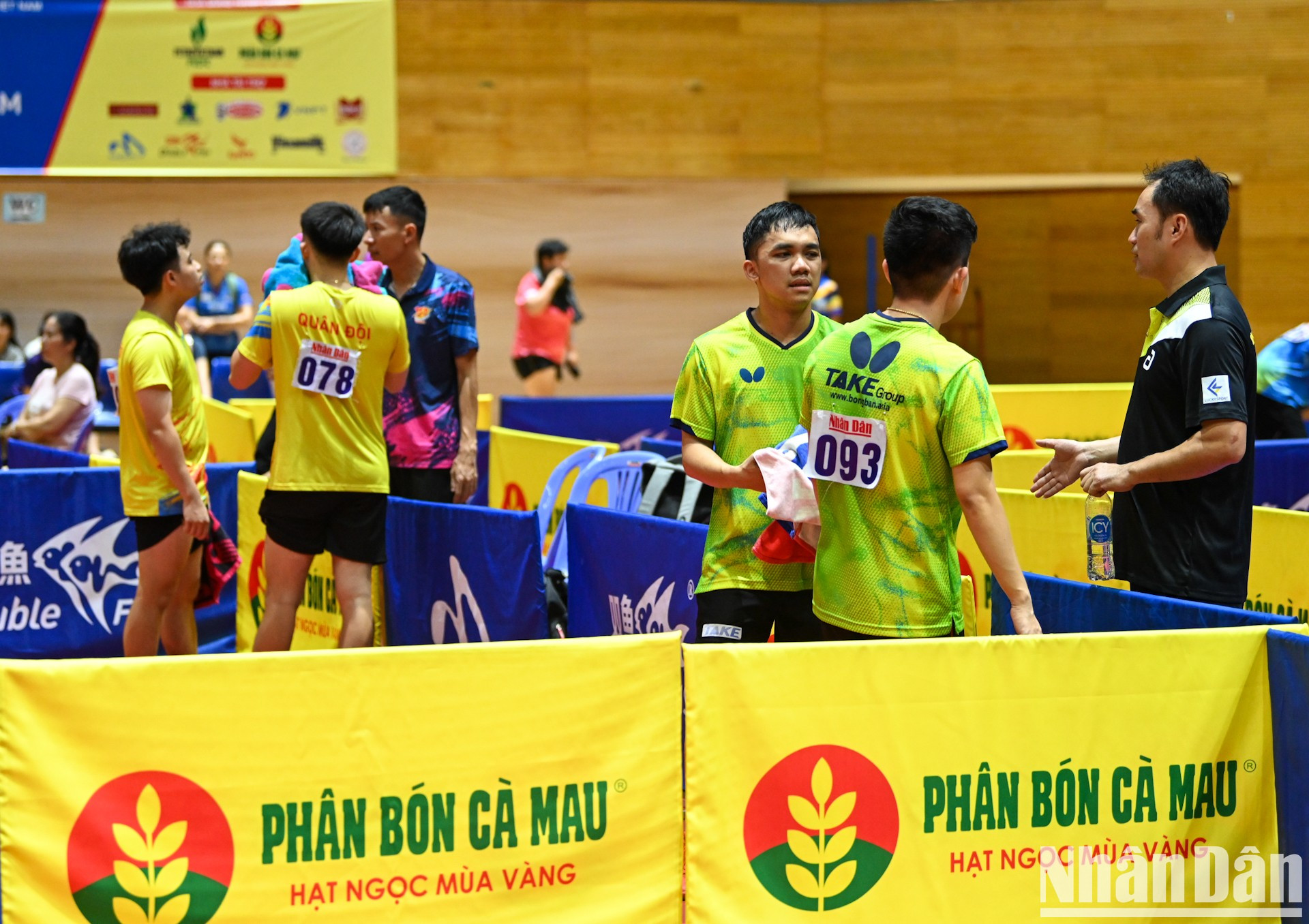 Dos entrenadores intercambian estrategias con los jugadores.