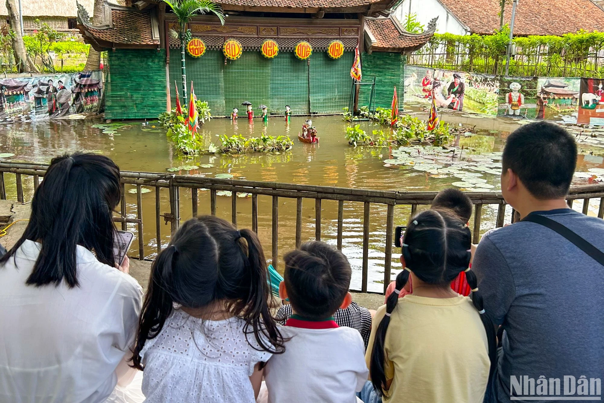 Una familia disfruta de un espectáculo de marionetas acuáticas interpretado por artistas de la provincia de Bac Ninh. Una familia disfruta de un espectáculo de marionetas acuáticas interpretado por artistas de la provincia de Bac Ninh.