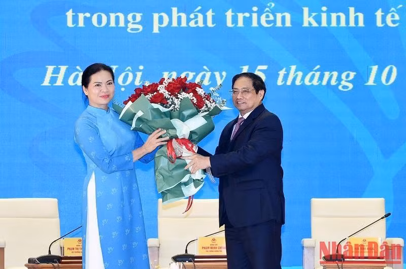 El primer ministro Pham Minh Chinh entrega flores para felicitar a la Unión de Mujeres de Vietnam.