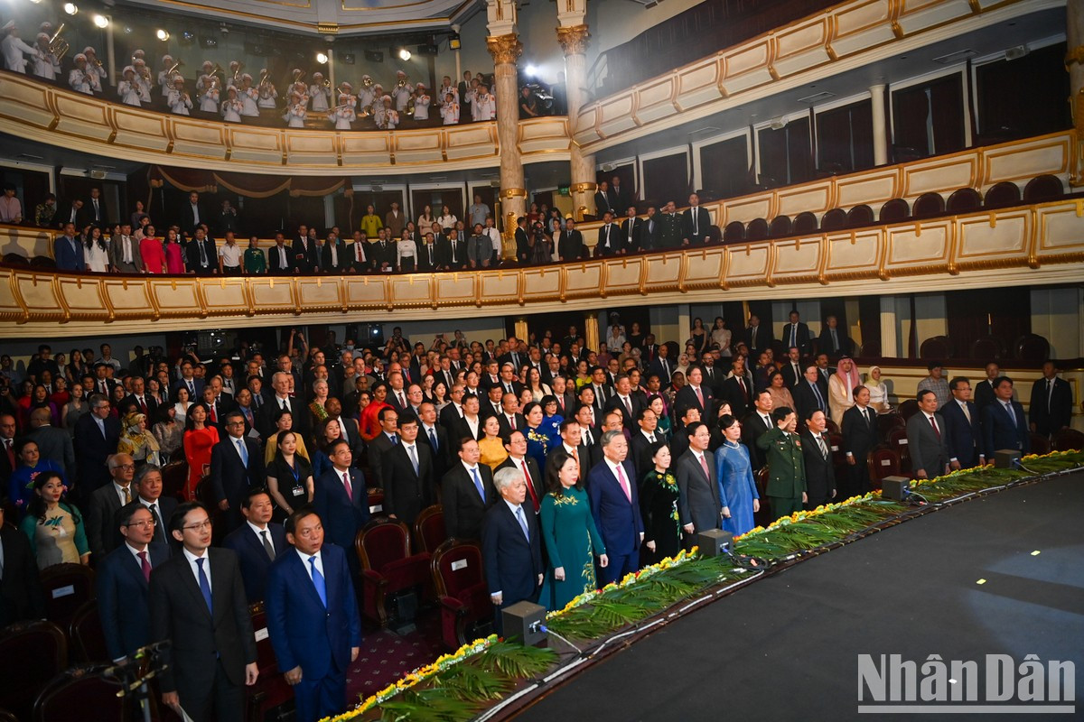 Los asistentes saludan a la bandera nacional.