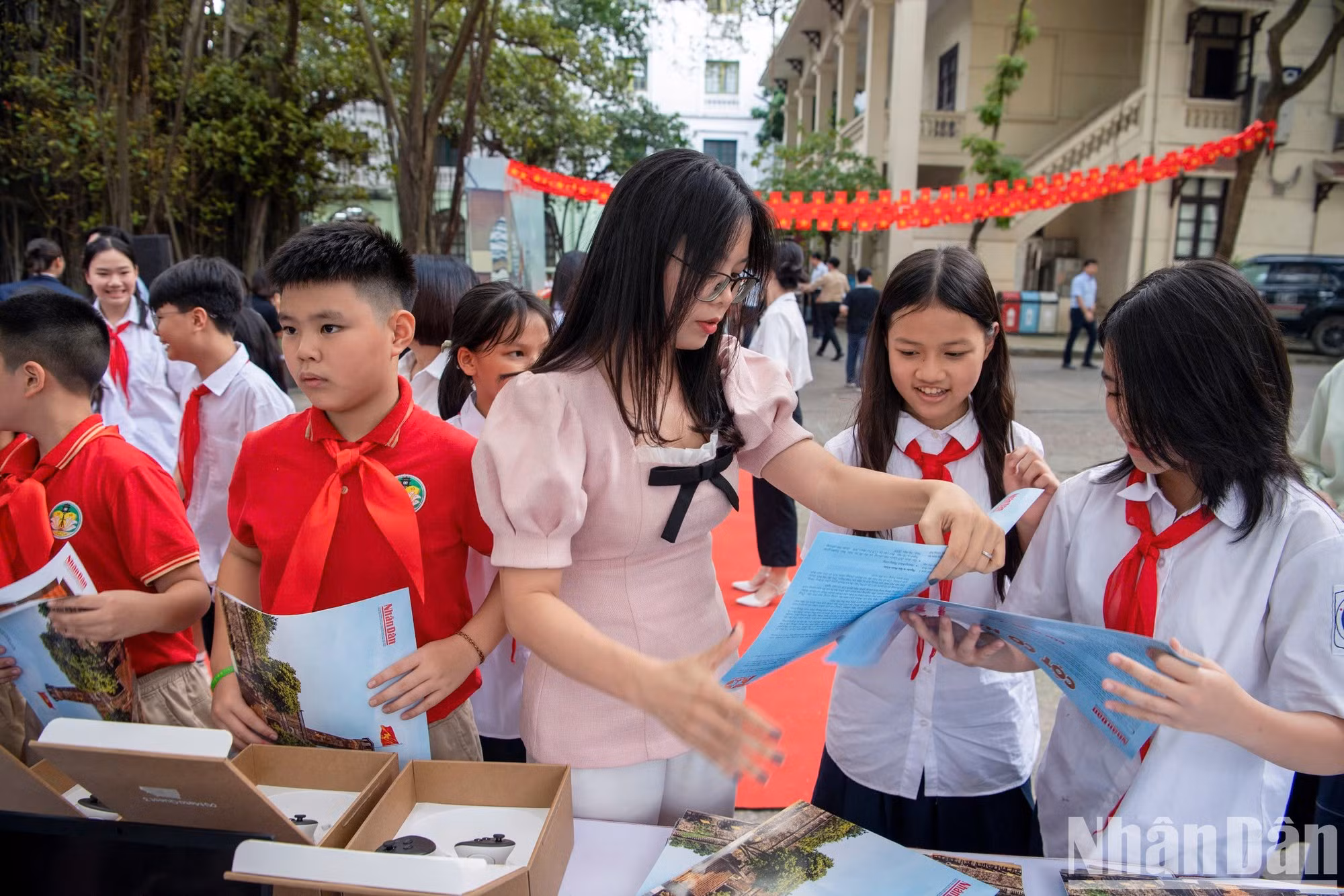 El comité organizador entrega a cada estudiante un suplemento especial del periódico Nhan Dan para que pudieran cortar y montar maqueta de la Torre de la Bandera de Hanói.