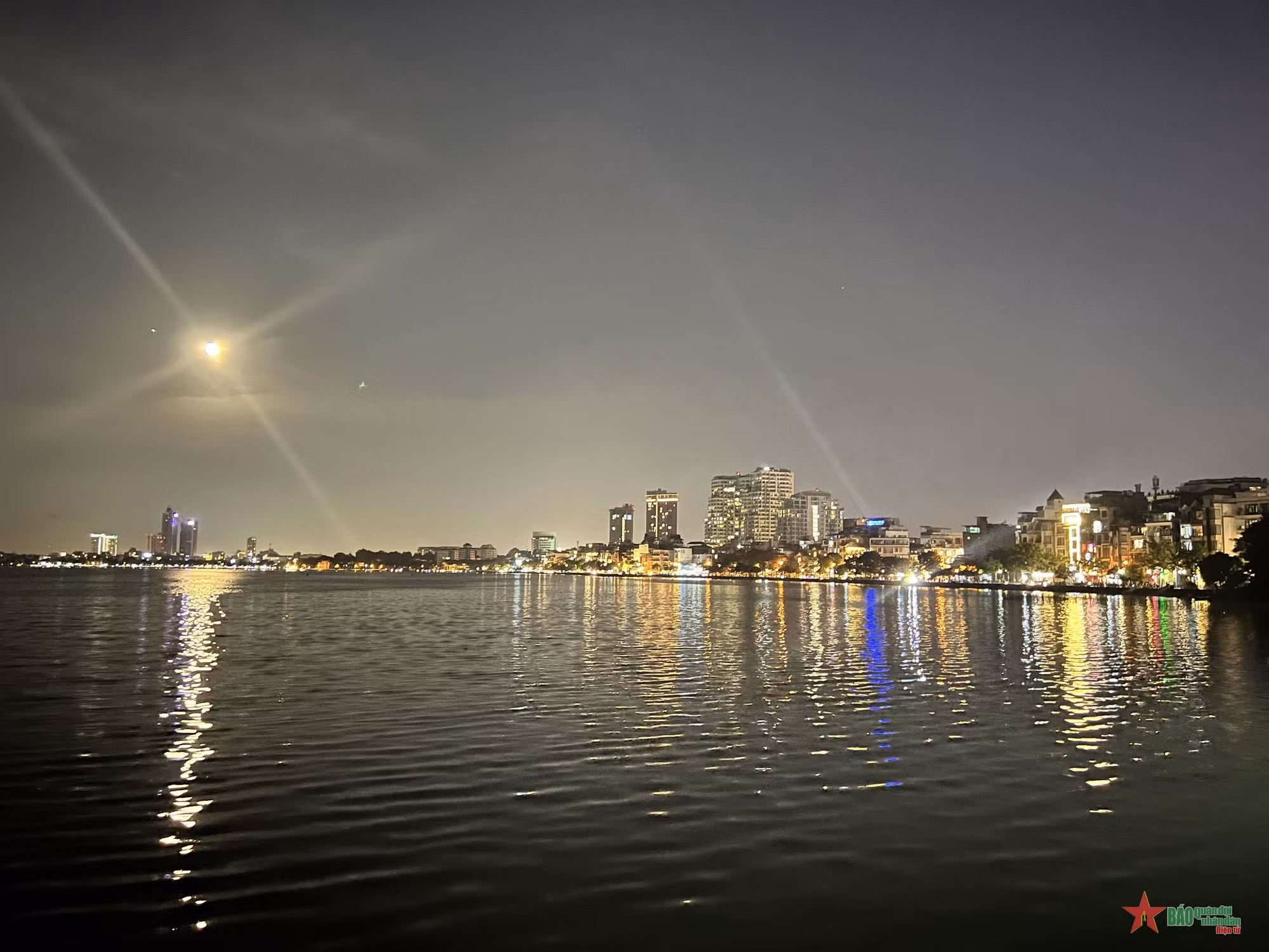 La noche pone en el lago Oeste los colores brillantes de las luces.