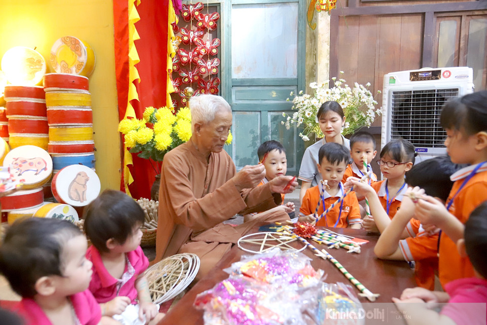 El artesano Nguyen Van Quyen enseña a los niños a hacer farolillos en forma de estrella.