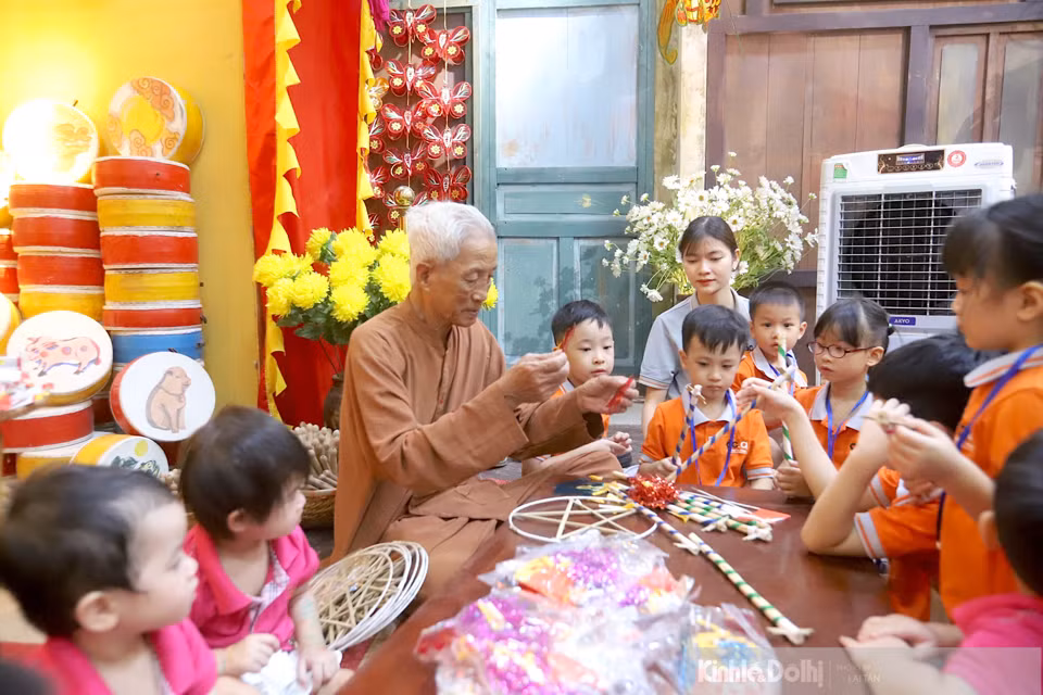 El artesano Nguyen Van Quyen enseña a los niños a hacer farolillos en forma de estrella.