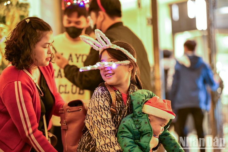 Los niños disfrutan del ambiente navideño con sus familias. Los niños disfrutan del ambiente navideño con sus familias.