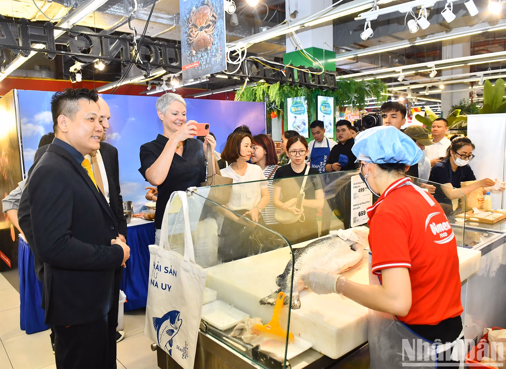 La embajadora Solbakken visita stands que presentan productos de salmón noruego en el sistema de supermercados WinMart.