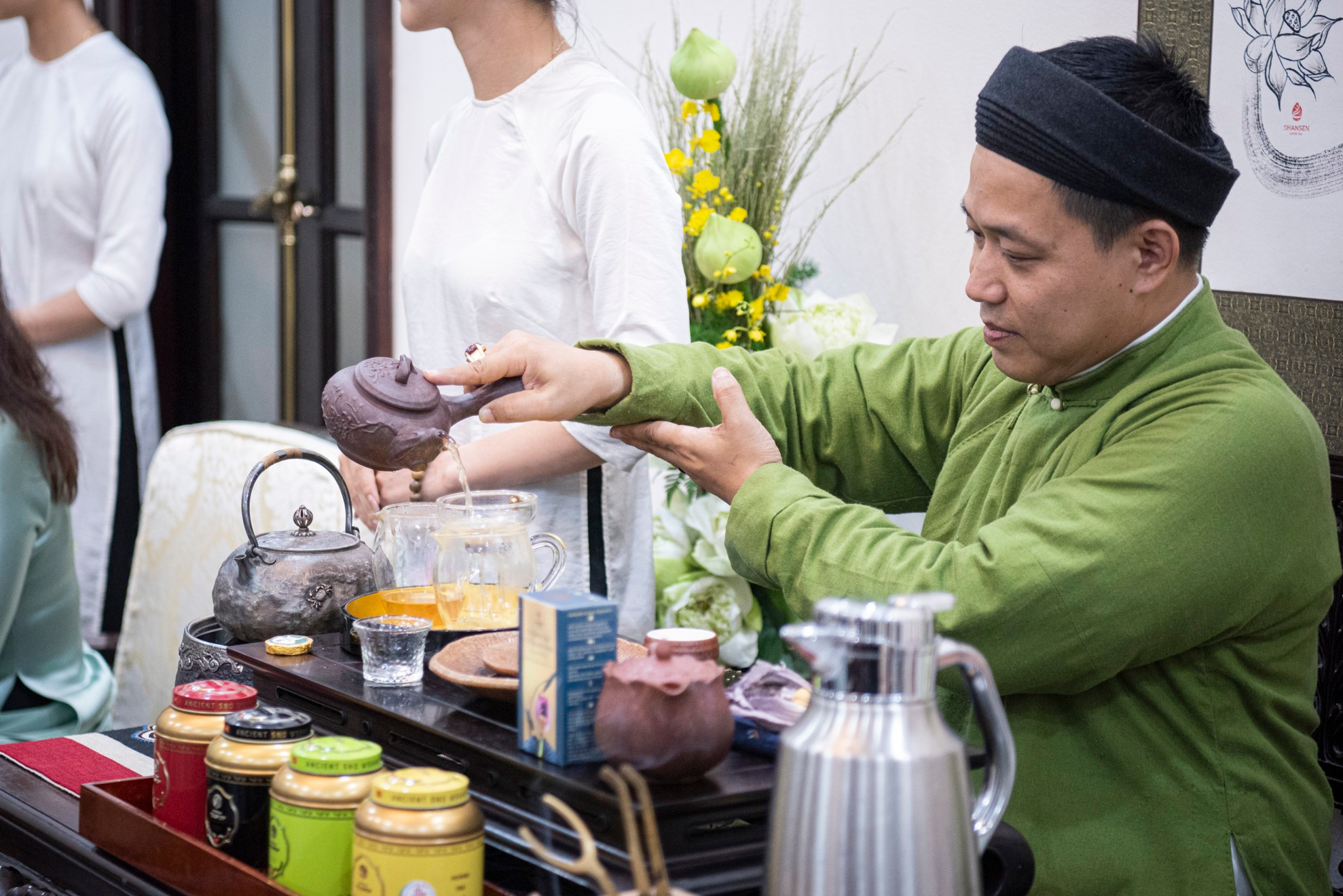 El artesano Dao Duc Hieu prepara té para las dos damas. El artesano Dao Duc Hieu prepara té para las dos damas.