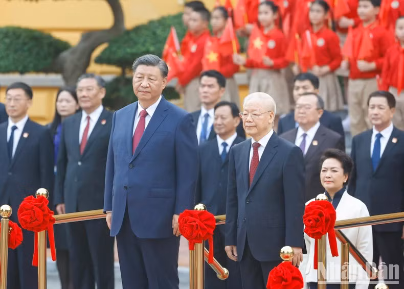 Ambos dirigentes se paran el podio de honor mientras se entonan los himnos nacionales de los dos países.
