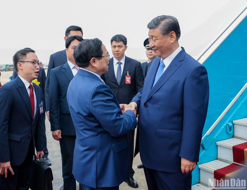 Pham Minh Chinh, miembro del Buró Político y primer ministro de Vietnam, da la bienvenida a Xi Jinping en el Aeropuerto Internacional de Noi Bai.