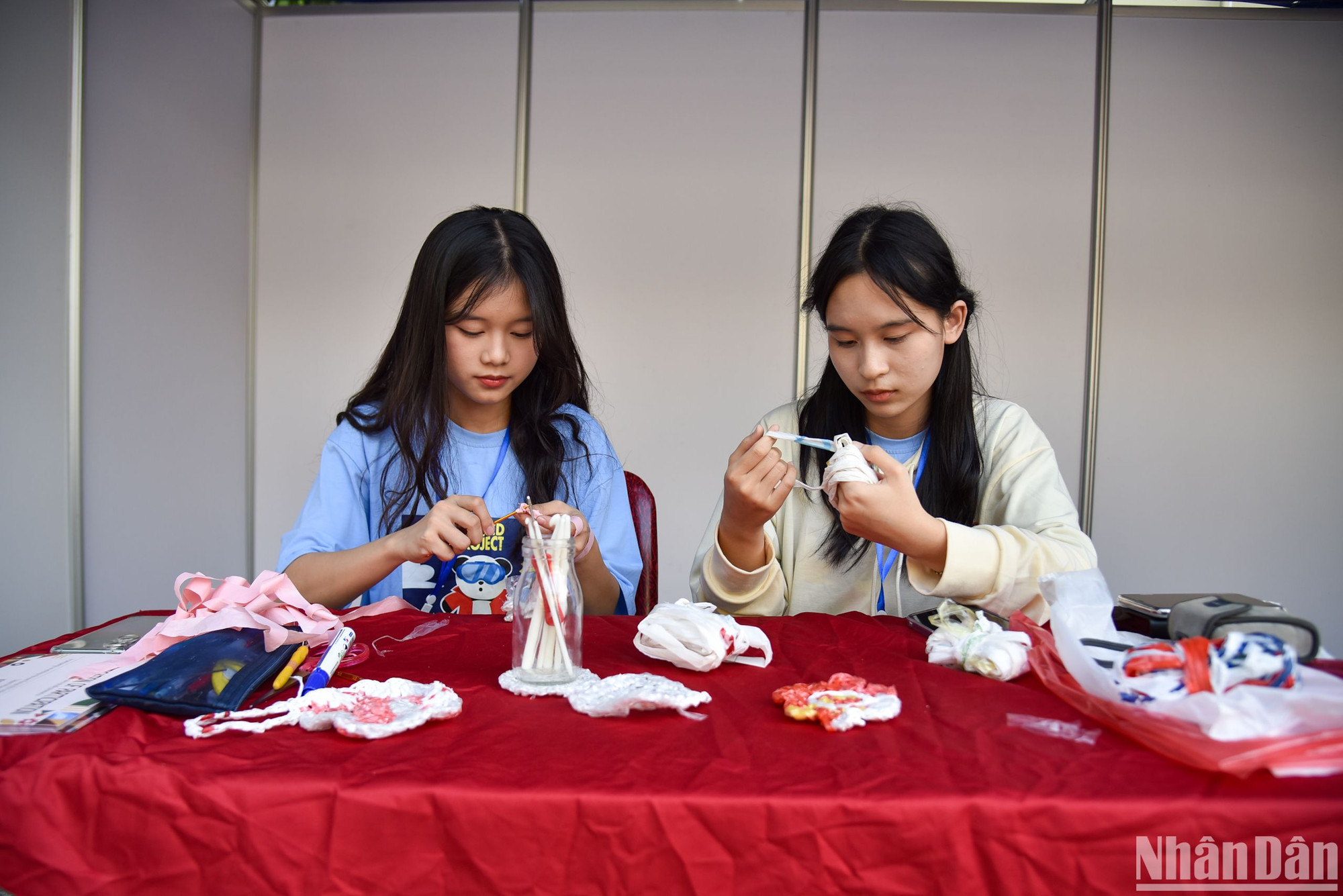Las niñas tejen flores con bolsas de plástico desechadas.