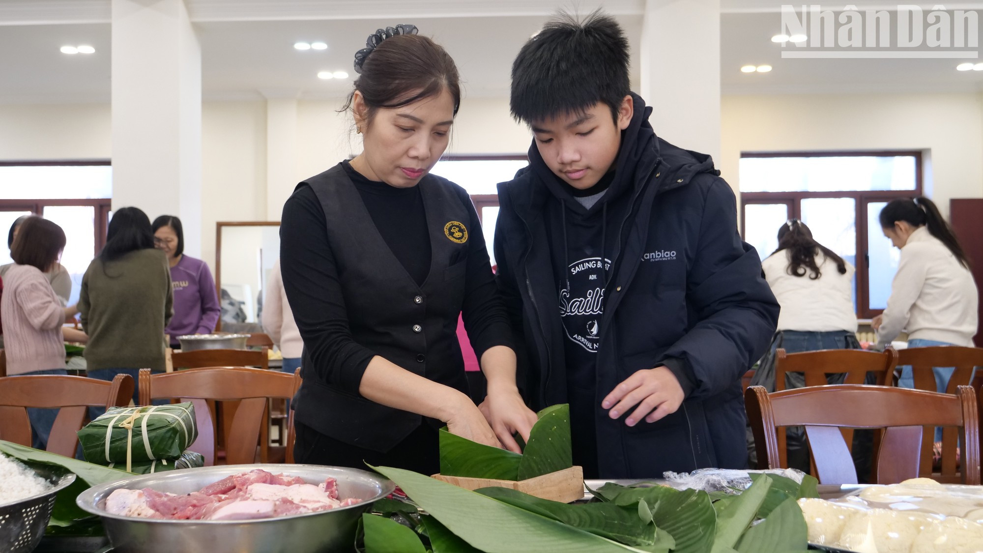 Guían a la generación joven para hacer el banh chung.