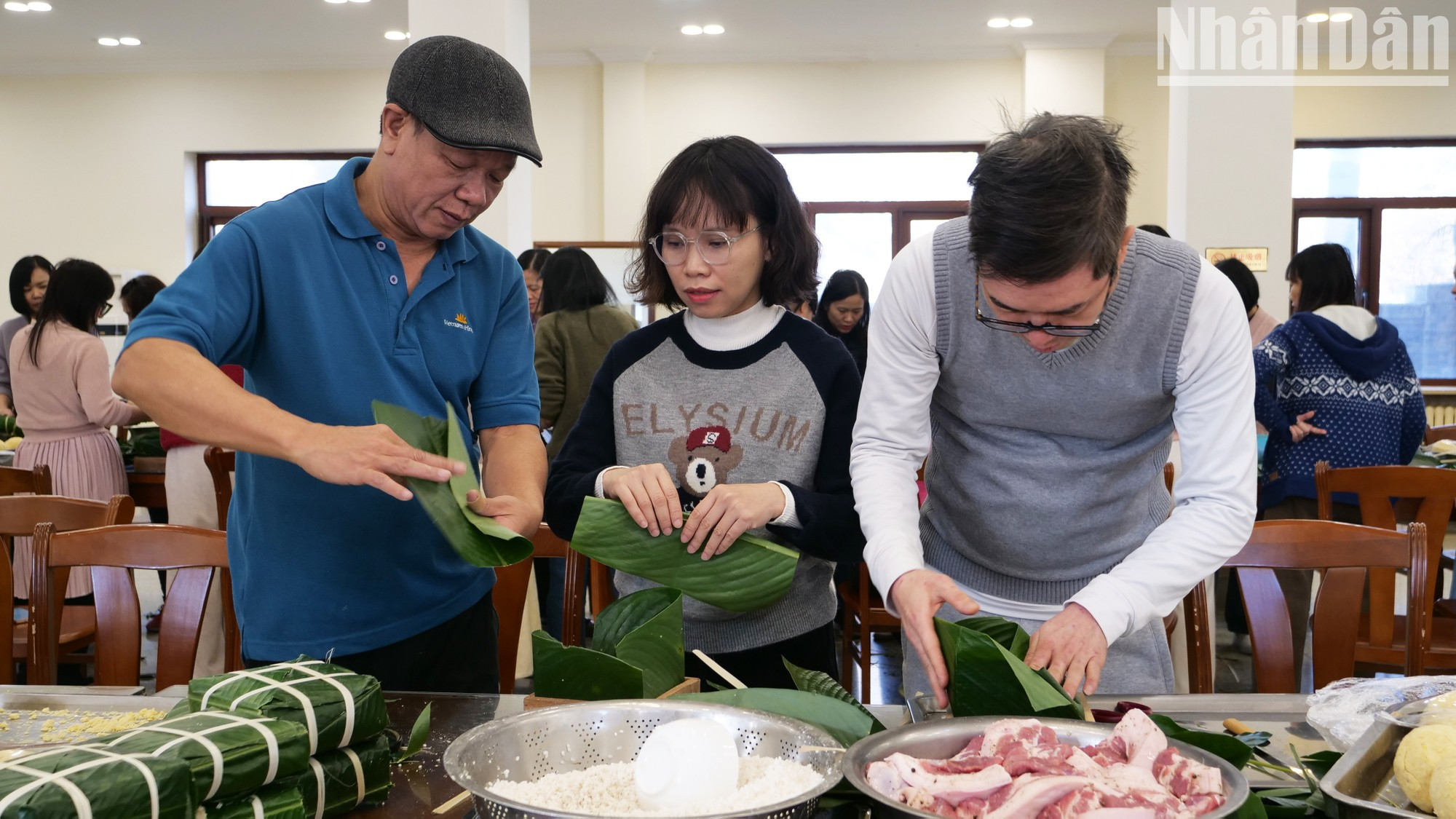 Aprenden de las personas mayores la experiencia de envolver el banh chung.